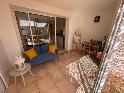 a living room with a blue couch and a table at Logement avec jardin et terrain de pétanque privé in Venelles