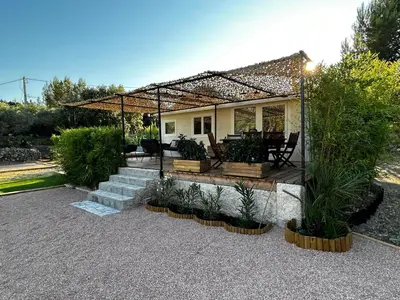 a house with a pergola and a patio with plants at L'Essentiel Room in Velaux
