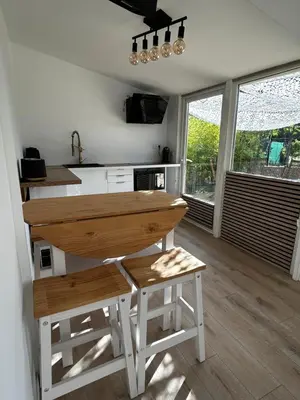 a kitchen with a wooden table and two stools at L'Essentiel Room in Velaux