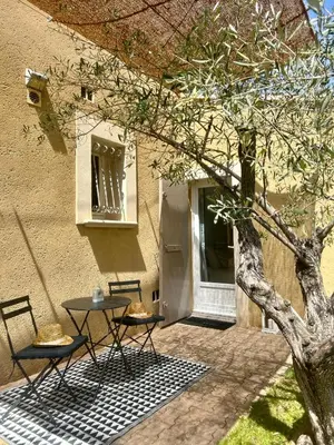 a table and two chairs next to a building at Chambre L in Les Taillades