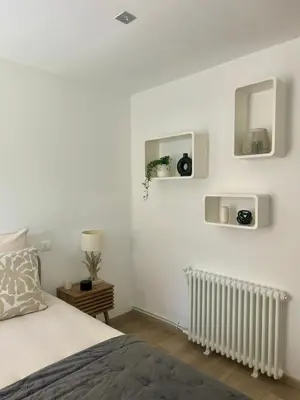 a white bedroom with a bed and a tv at Chambre L in Les Taillades