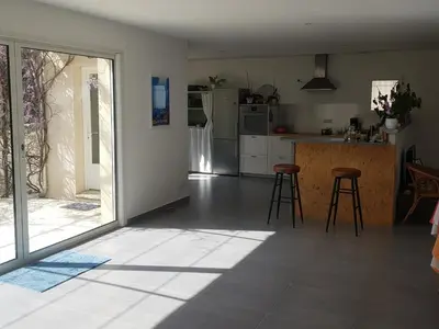 a kitchen with a large sliding glass door and a kitchen with stools at L'embellie in Châteaurenard