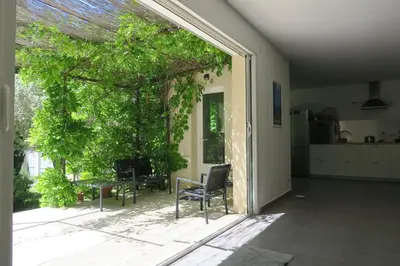 a patio with a chair and a table and a tree at L'embellie in Châteaurenard