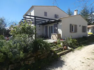 a small white house with a stone wall at Maison Viens in Viens