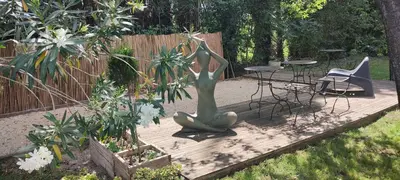 a garden with a statue and a table and chairs at Mas Cabannes en Provence in Cabannes