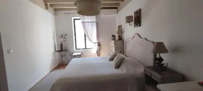 a bedroom with a white bed and a window at Mas Cabannes en Provence in Cabannes