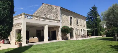 a large stone building with a grass yard at Mas Cabannes en Provence in Cabannes