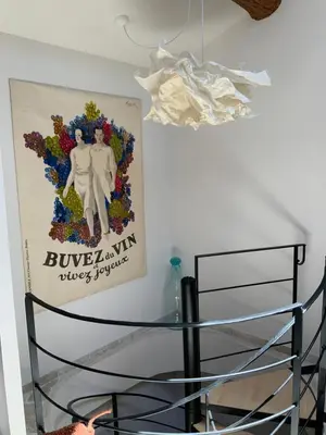 a glass table in a room with a poster on the wall at Maisonnette de charme 60m2 in Robion en Luberon