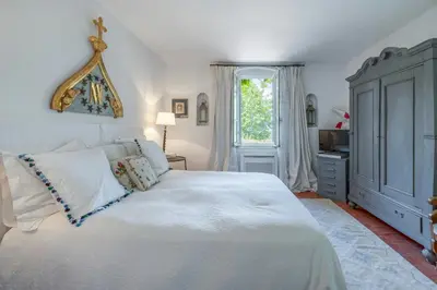 a bedroom with a large white bed and a window at 18Th Century Bastide With Heated Pool In Provence in Apt