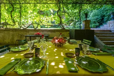a table with green plates and glasses on a yellow table cloth at 18Th Century Bastide With Heated Pool In Provence in Apt