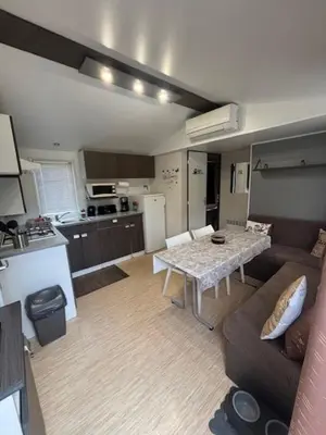 a kitchen with a wooden table in a room at mobil home AU SOLEIL in La Roque-dʼAnthéron