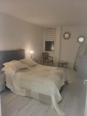 a bedroom with a large bed and a chair at Espace Forbin in Aix-en-Provence