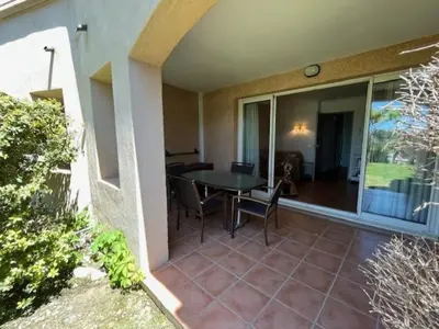 a patio with a table and chairs on a house at Appartement de charme sur le domaine de Pont Royal à Mallemort, en rez-de-jardin avec terrasse & piscine et vue sur le Golf in Mallemort