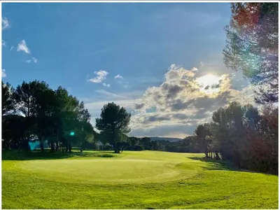 a green golf course with the sun in the background at Appartement de charme sur le domaine de Pont Royal à Mallemort, en rez-de-jardin avec terrasse & piscine et vue sur le Golf in Mallemort