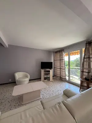 a living room with a white couch and a tv at Aix en Provence, dans grande résidence arborée, appartement de 80m2 in Aix-en-Provence