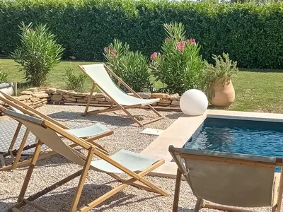 a couple of chairs and a swimming pool at Villa de charme à Cucuron au pied du luberon in Cucuron