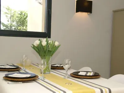 a table with plates and glasses and a vase of flowers at Villa de charme à Cucuron au pied du luberon in Cucuron