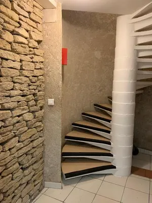 a staircase in a room with a stone wall at La parenthèse sur la sorgue in LʼIsle-sur-la-Sorgue