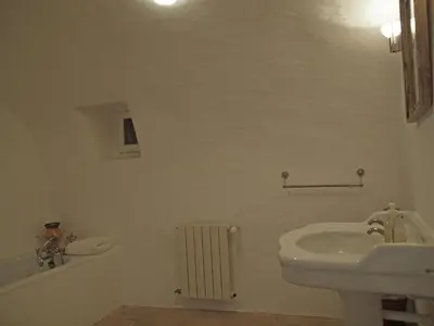a white bathroom with a sink and a radiator at Oppède Villa with Private Pool in Oppède