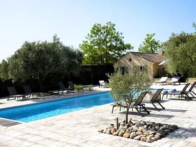 a swimming pool with chairs and trees and a house at Oppède Villa with Private Pool in Oppède