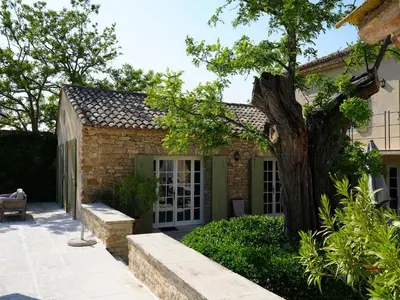 a brick house with a tree in the yard at Oppède Villa with Private Pool in Oppède