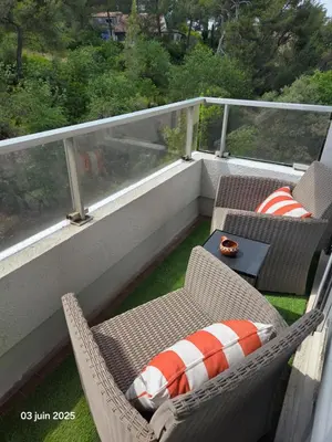 a balcony with two wicker chairs and a table at La Pineda de Provence in Aix-en-Provence