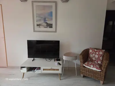 a living room with a tv and a chair at La Pineda de Provence in Aix-en-Provence