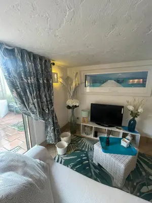 a living room with a white couch and a tv at Petite Maison provencale in Lagnes