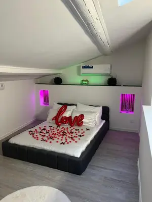 a bedroom with a bed with red roses on it at Trésor Étoile, luxe & lumière - Duplex 4 personnes in Pertuis