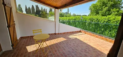 a chair and a table on a balcony with a view at Villa en Provence avec piscine in Sénas