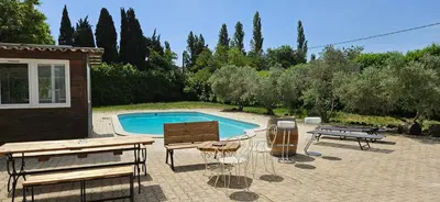 a patio with a table and chairs and a pool at Villa en Provence avec piscine in Sénas