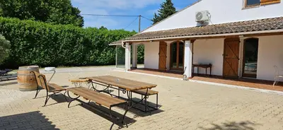 a picnic table and a bench in front of a building at Villa en Provence avec piscine in Sénas