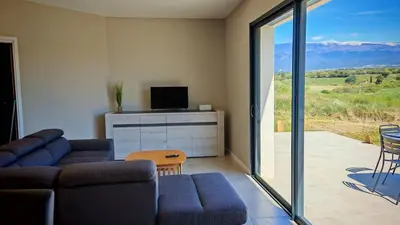 a living room with a couch and a sliding glass door at Cap sur le Ventoux in Mormoiron
