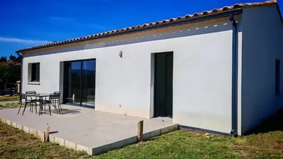 a white house with a patio and a table at Cap sur le Ventoux in Mormoiron