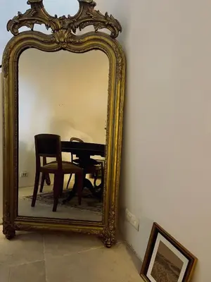 a mirror with a table and a chair in front of it at La Biscornue in Lauris