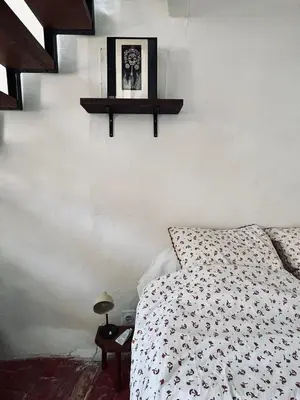 a bedroom with a bed and a shelf on the wall at La Biscornue in Lauris