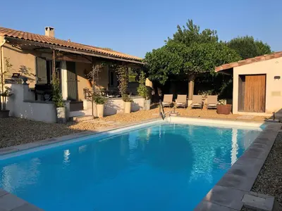 a blue swimming pool in front of a house at Haus PETIT REVE in Oppède in Oppède