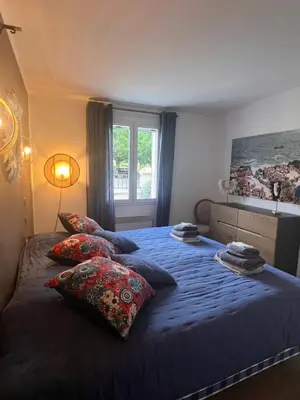 a bedroom with a blue bed with pillows and a window at Haus PETIT REVE in Oppède in Oppède