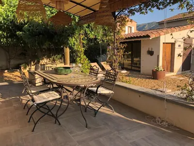 a wooden table and chairs on a patio at Haus PETIT REVE in Oppède in Oppède