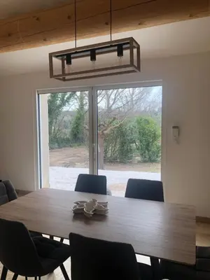 a dining room table with chairs and a large window at L'olivier in Aureille