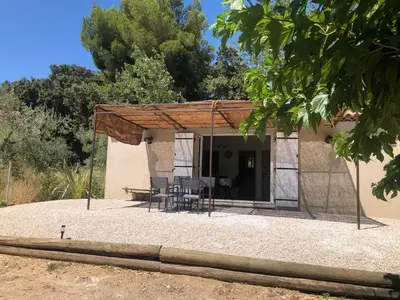a patio with a table and chairs in front of a house at L'olivier in Aureille