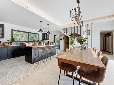 a large kitchen with a wooden table and chairs at La villa dans les arbres - Triangle d'or du Luberon in Ménerbes