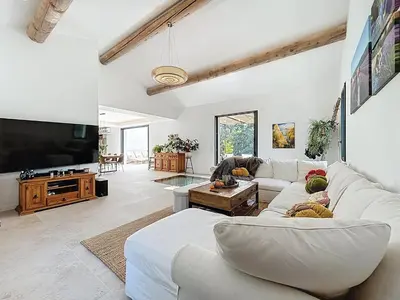 a living room with white furniture and a flat screen tv at La villa dans les arbres - Triangle d'or du Luberon in Ménerbes