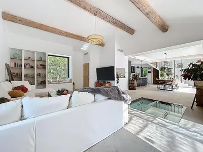 a living room with a white couch and a tv at La villa dans les arbres - Triangle d'or du Luberon in Ménerbes