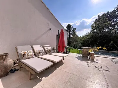 a group of lounge chairs sitting on a patio at La villa dans les arbres - Triangle d'or du Luberon in Ménerbes