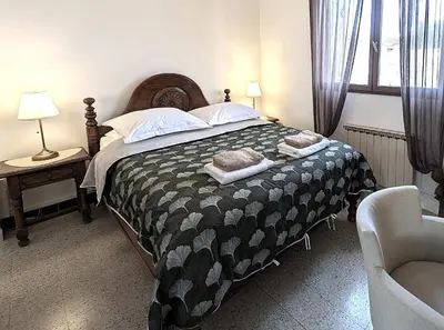 a bedroom with a bed with a black and white comforter at LE CHESTER - Maison de charme en Provence avec piscine près de L'Isle-sur-la-Sorgue in Velleron