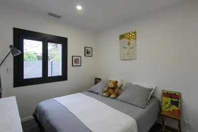 a teddy bear sitting on a bed in a bedroom at Villa rosalie L'Isle-sur-la-Sorgue in LʼIsle-sur-la-Sorgue
