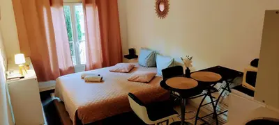 a bedroom with a bed with a table and a television at Provence apartments in Aix-en-Provence
