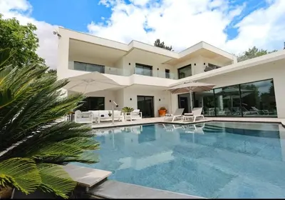 a large house with a swimming pool in front of it at Villa contemporaine de luxe in Aix-en-Provence