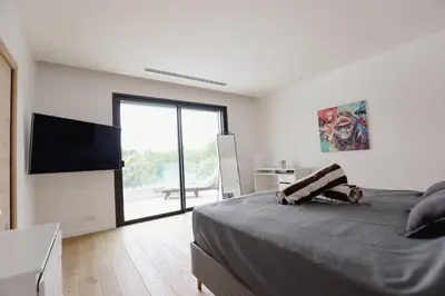 a bedroom with a bed and a flat screen tv at Villa contemporaine de luxe in Aix-en-Provence